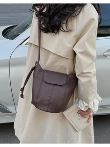 Close-up of deep brown litchi pattern leather bucket bag with elegant stitching details