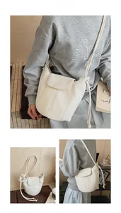 Detail of white lychee texture bucket bag featuring minimalist flap and adjustable strap