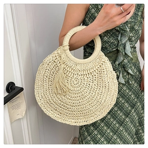 Détail du sac en paille tissé main avec poignées rondes et longues franges