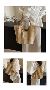 Détail du sac cabas en paille tissé à rayures avec pompon perlé et anses tressées