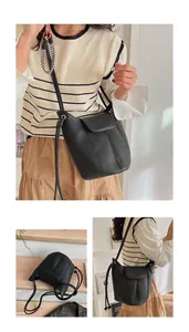 Detail view of a black bucket bag in lychee pattern PU leather with magnetic closure