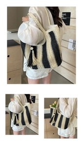 Détail du sac cabas tissé en paille avec rayures noir et blanc et pompon en perles