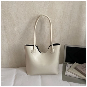 Macro shot of off-white PU leather tote bag with U-shaped cutout and slim dual handles
