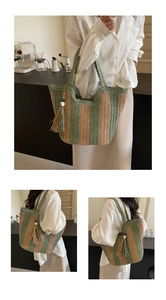 Détail d'un sac cabas tissé à rayures vertes et beiges avec un pompon décoratif