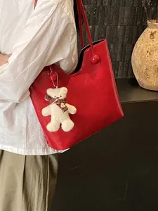 Large red leather tote bag with round bead accents and a cute bear charm for women