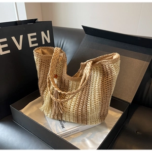 Détail d'un sac cabas en paille dégradé beige et marron avec anses en corde