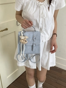 Minimalist light blue faux leather backpack with plush bear charm and silver buckles