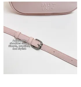 Détail de la bandoulière réglable en cuir rose avec une boucle en métal argenté élégante