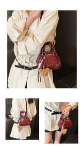 Detail of burgundy shell bag with metal rivets, silk scarf, and cute bear charm
