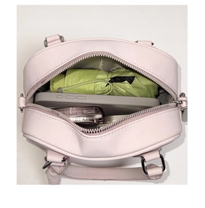 Vue de dessus du petit sac à main rose montrant le rangement interne pour accessoires