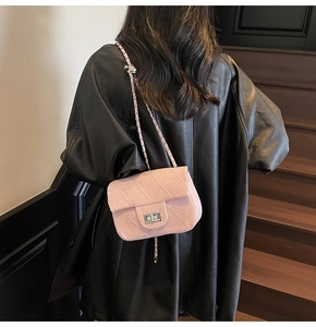 Pink tweed crossbody bag featuring silver chain strap and metallic lock on black coat