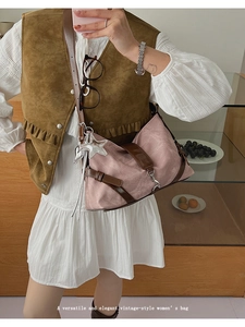 Detail of vintage pink shoulder bag with leather straps and charms on a model