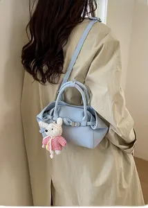Vue arrière d'un mannequin portant un sac seau en cuir bleu clair avec un lapin mignon
