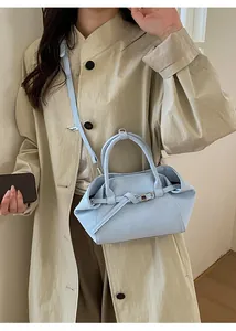 Sac bandoulière bleu clair porté avec un trench beige pour un style élégant et moderne