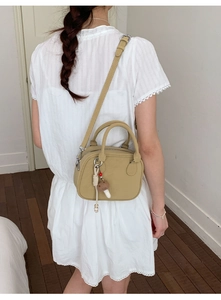 Sac à bandoulière en cuir PU kaki avec breloque champignon porté par un mannequin