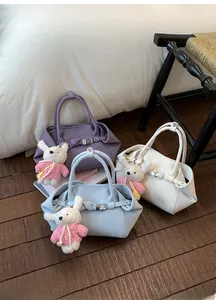 Détail de sacs seaux en violet, bleu et blanc avec des breloques de lapin mignon