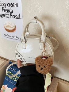 Chic off-white shell handbag with metallic rivets and a brown bear charm for women