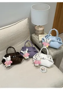 Détail de sacs à main élégants en quatre couleurs avec pendentifs lapin mignons et sangles