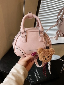 Pink minimalist shell handbag with silver rivets, top handles and brown plush bear charm