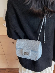 Light blue denim quilted crossbody bag with silver chain strap and metal turn-lock closure