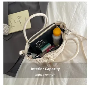Intérieur spacieux du sac seau tissé montrant les essentiels et la bandoulière en cuir
