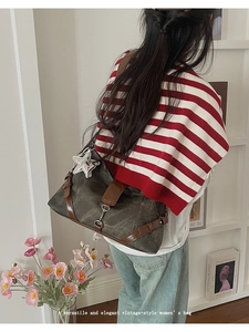 Close-up of retro canvas shoulder bag featuring star charm and leather trim details