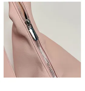 Detail eines silbernen Metallreißverschlusses an einer hellrosa Leder-Tasche