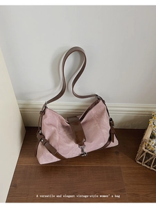 Detail of vintage pink suede shoulder bag with brown leather strap and metal buckle