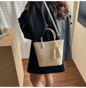 Détail du sac seau tissé crème avec glands élégants et bandoulière réglable chic