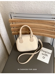 Détail du sac à main en cuir crème avec logo MUTING gaufré et fermeture éclair