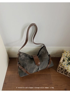 Detail showing vintage washed gray canvas material with brown leather straps and metal hooks
