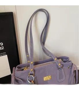 Detail of purple tote bag with golden rivets, reinforced handles and side straps