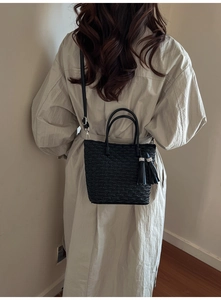 Détail du sac seau noir plissé avec pompon et bandoulière réglable pour femmes
