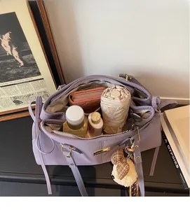 Spacious interior of purple leather tote bag showing umbrella and wallet storage