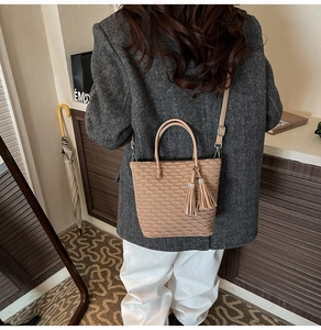 Détail d'un sac seau beige avec texture éventail, glands et détails en strass