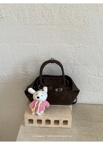 Détail du sac à main en daim marron foncé avec charm lapin mignon et boucle rétro