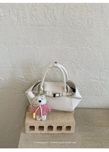 Détail du sac cabas blanc avec design plissé et accessoire d'ours en peluche