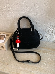 Sac à bandoulière cylindrique noir minimaliste avec sangle réglable et charme de champignon