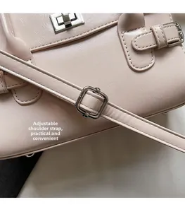 Detail view of adjustable shoulder strap with silver buckle and pink faux leather texture