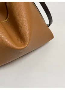 Close-up of premium pebbled leather texture on a deep caramel brown tote bag