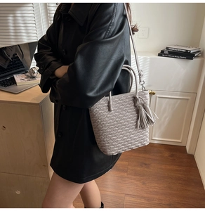 Vue détaillée d'un sac seau taupe avec gaufrage festonné et élégant pendentif à franges