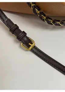 Detail of adjustable dark brown leather strap with polished gold-tone metal buckle