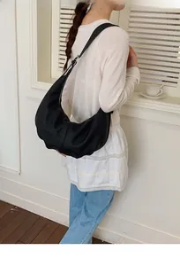 Detail der minimalistischen schwarzen Hobo-Tasche aus Leder mit natürlicher Kieselstruktur