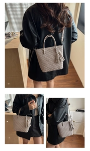Détail du sac seau beige gaufré avec poignées rondes et pendentif à pompon