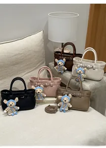 Handtaschen aus Leder mit Litschimuster in fünf Farben und süßen Bärenanhängern