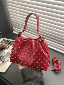 Bright red studded leather handbag with pearl texture bucket style and shoulder strap