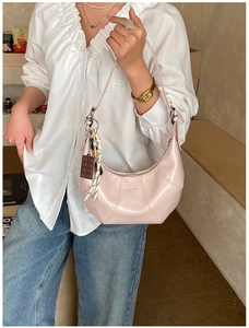 Pink hobo bag with Love & Desire print shown on model in a cozy indoor setting