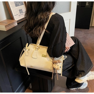 Chic beige leather tote bag with a charming bow tie and a cute puppy plush charm pendant