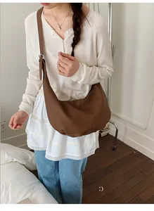 Detailaufnahme der braunen Hobo-Tasche mit Lederstruktur und verstellbarer Silberschnalle