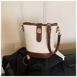 Dettaglio della borsa a secchiello vintage con cuciture a contrasto e logo dorato